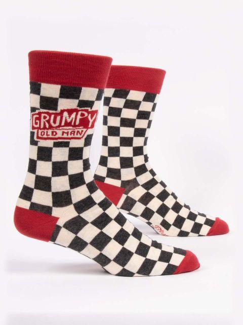 Men's black-and-cream checkerboard crew socks shown from the side with a red "Grumpy Old Man" badge and red cuff