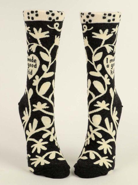 Front view of the black 'I made a good kid' socks shown flat, showing the heart text and floral vine pattern on both