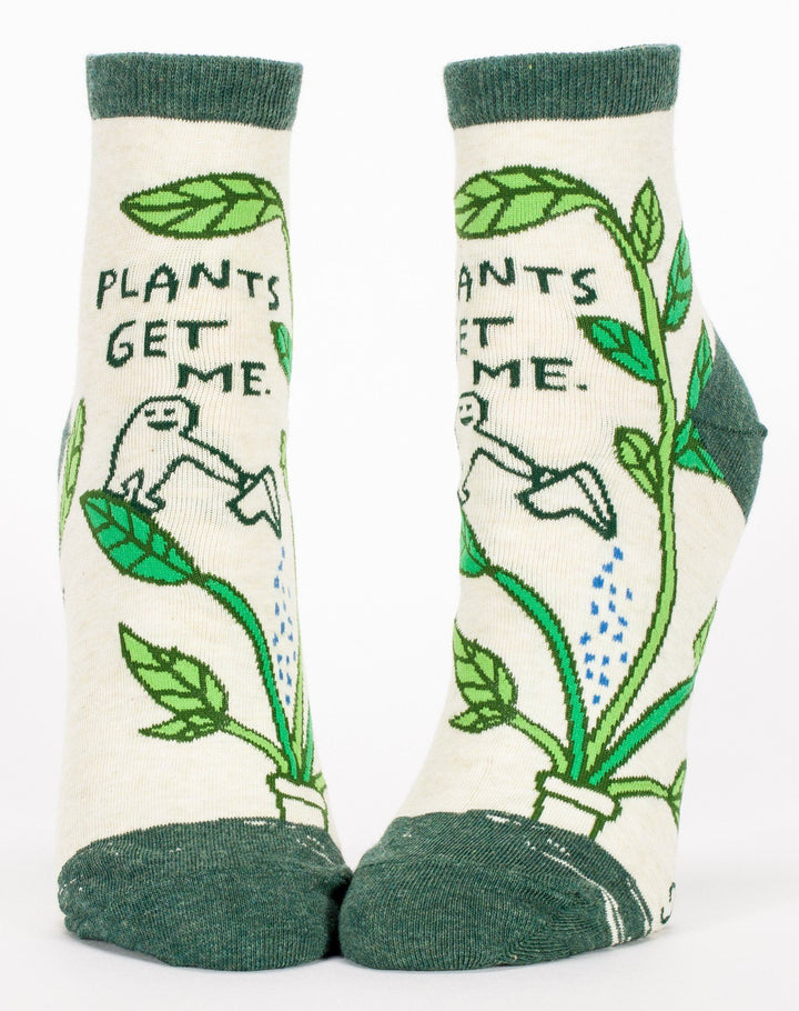 Pair of cream ankle socks with green vines, a watering character, and the text Plants get me