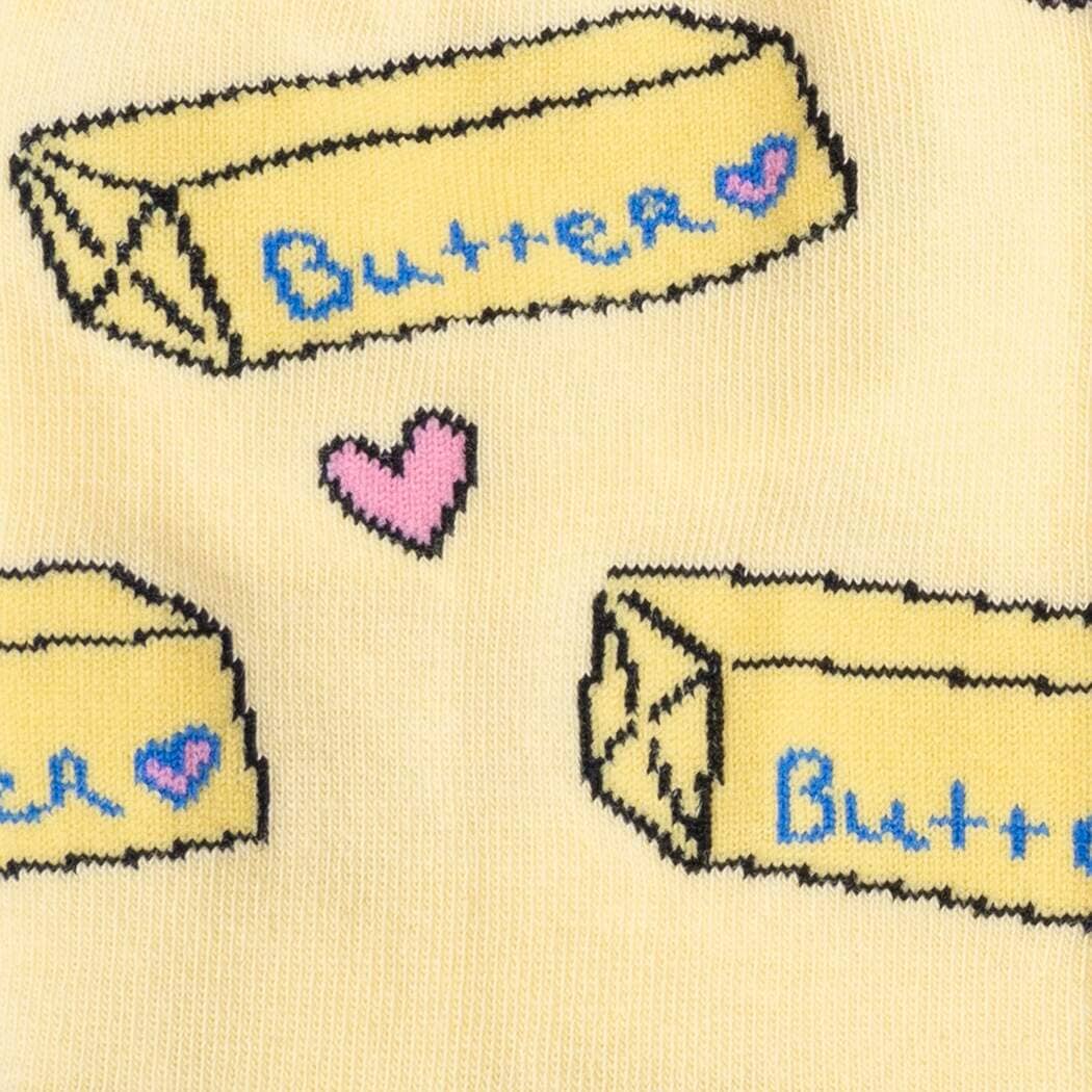 Close-up knit detail of the labeled butter sticks and a single pink heart