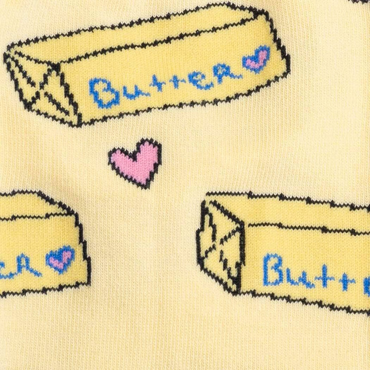 Close-up knit detail of the labeled butter sticks and a single pink heart
