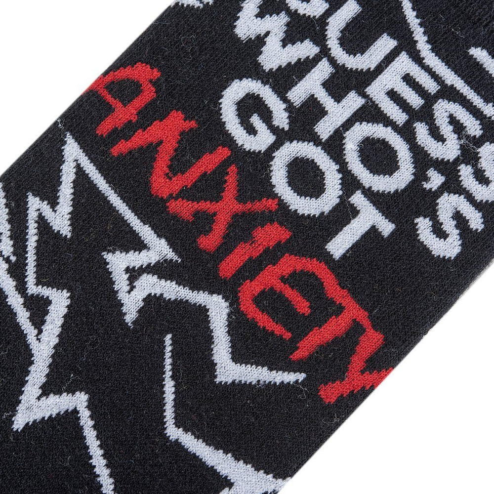 Close-up of the anxiety socks showing the red "Anxiety" wordmark and "Guess Who's Got" lettering