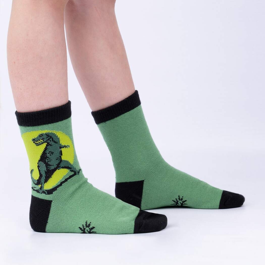 Child wearing the green T-rex dinosaur crew socks, side view