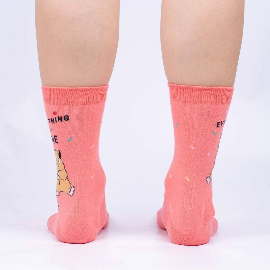 Back view of the coral socks worn on legs, showing the sprinkle pattern and partial lettering