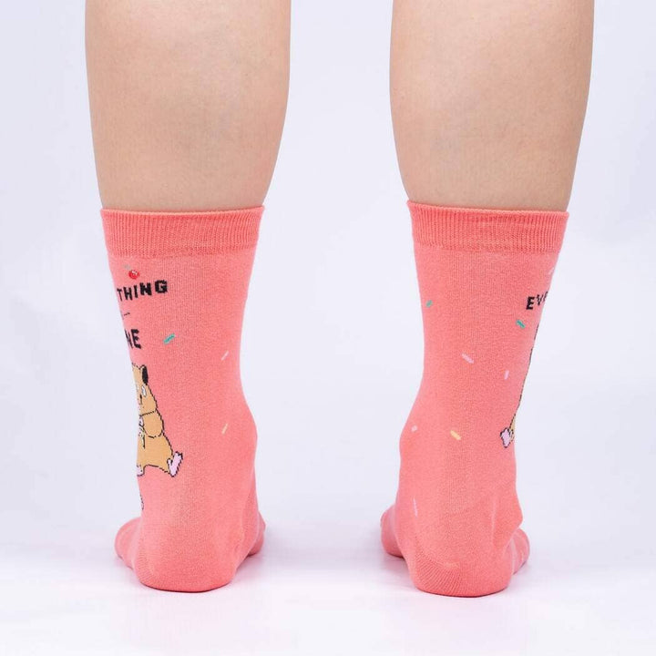 Back view of the coral socks worn on legs, showing the sprinkle pattern and partial lettering