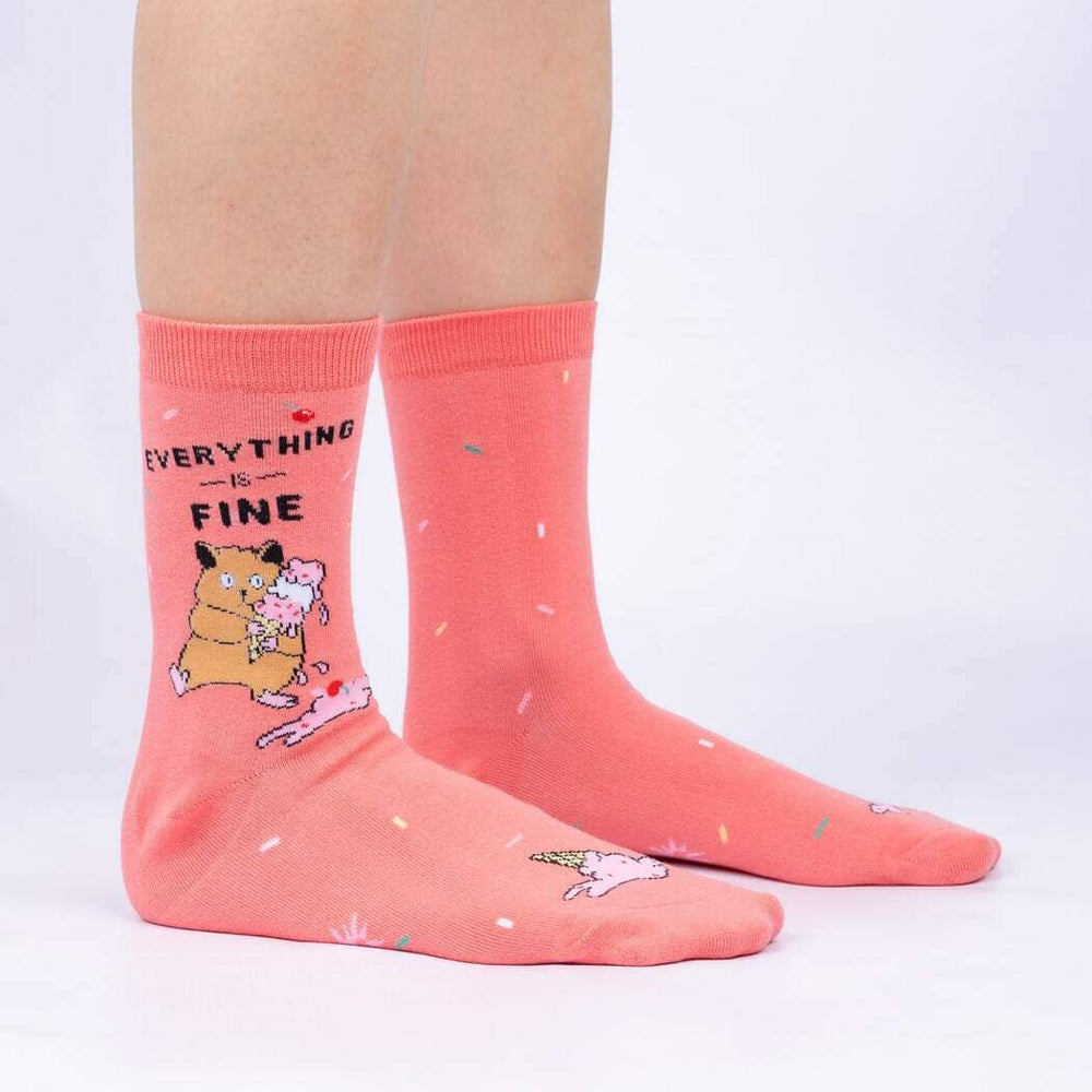 Side view of the coral socks worn on legs, showing the confetti sprinkles and cat illustration