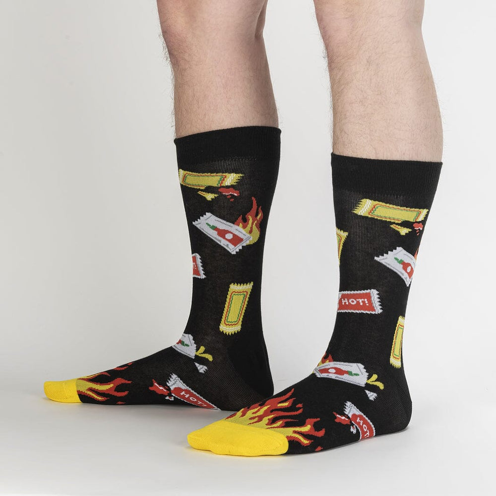 Extra Hot sauce socks worn on a model's legs, side view showing packets and flames