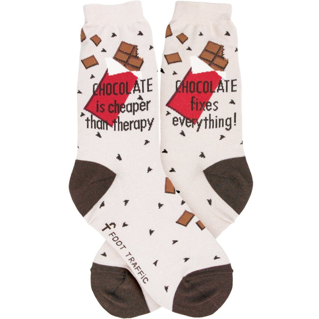 Pair of cream chocolate crew socks laid flat, one reading "Chocolate is cheaper than therapy," the other "Chocolate fixes everything!"