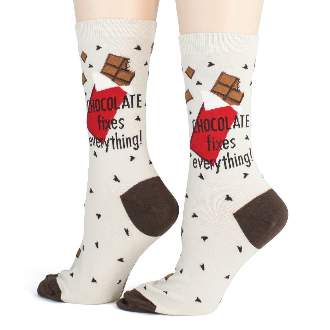 Three-quarter view of the chocolate socks on feet, candy chips scattered across the cream knit