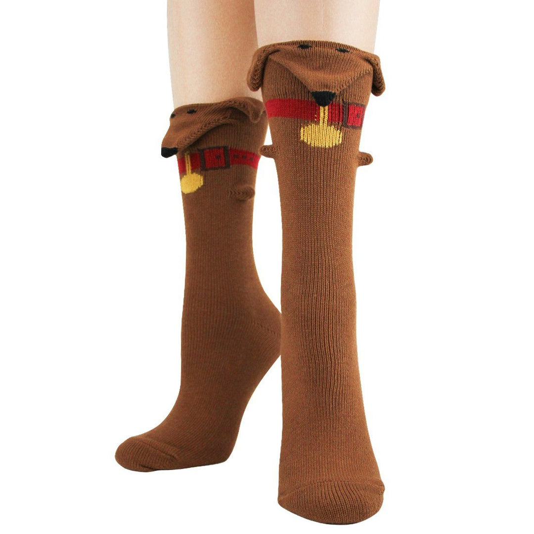 Pair of women's brown dachshund 3-D crew socks worn on legs, each with a knitted dog face, floppy ears, red collar and gold tag at the cuff