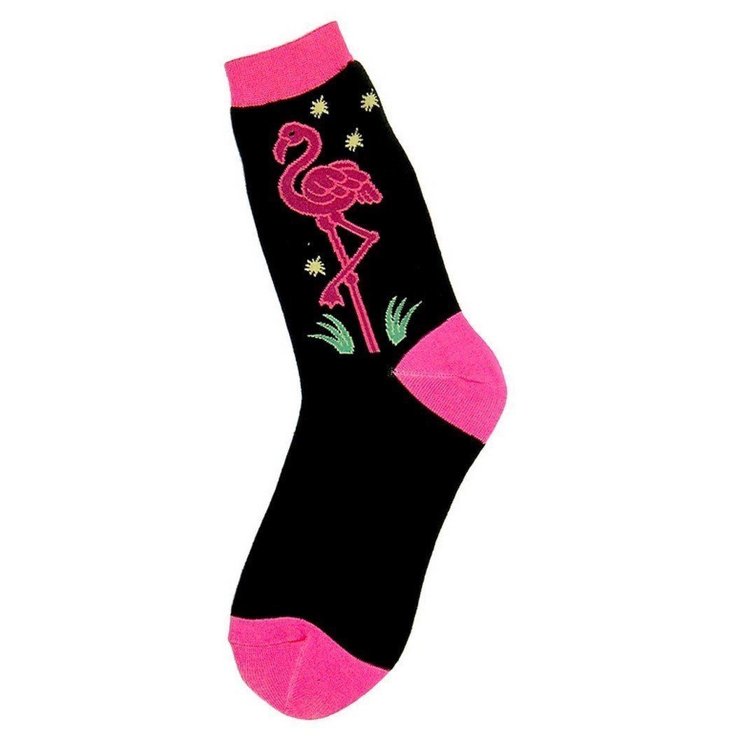 Women's black crew sock with a hot-pink flamingo standing on one leg amid gold stars and green grass; bright pink cuff, heel, and toe.