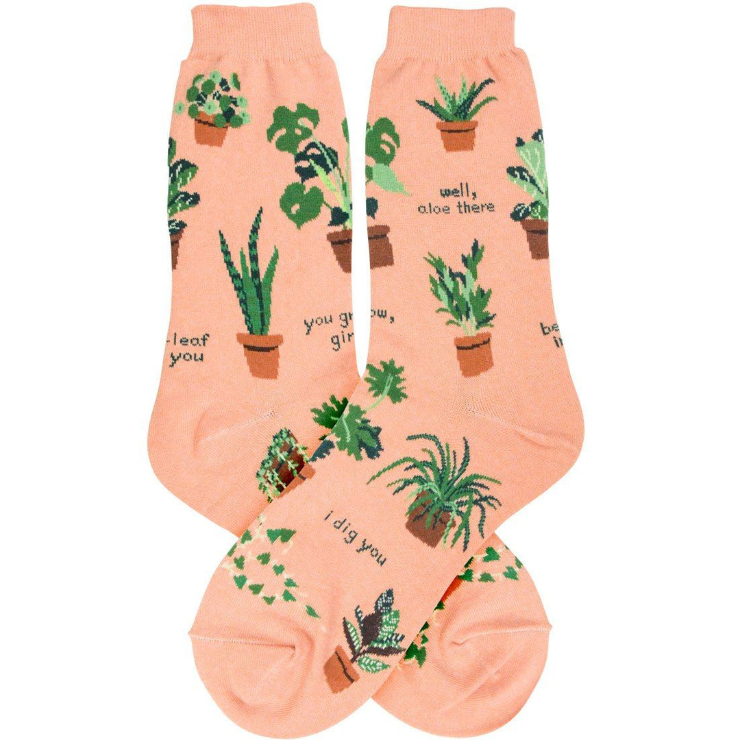 Pair of peach plant-themed crew socks laid flat with potted houseplants and puns like "well, aloe there" and "i dig you"