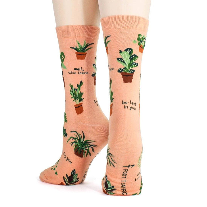 Rear view of the worn plant socks showing "be-leaf in you" and "Foot Traffic" branding on the sole