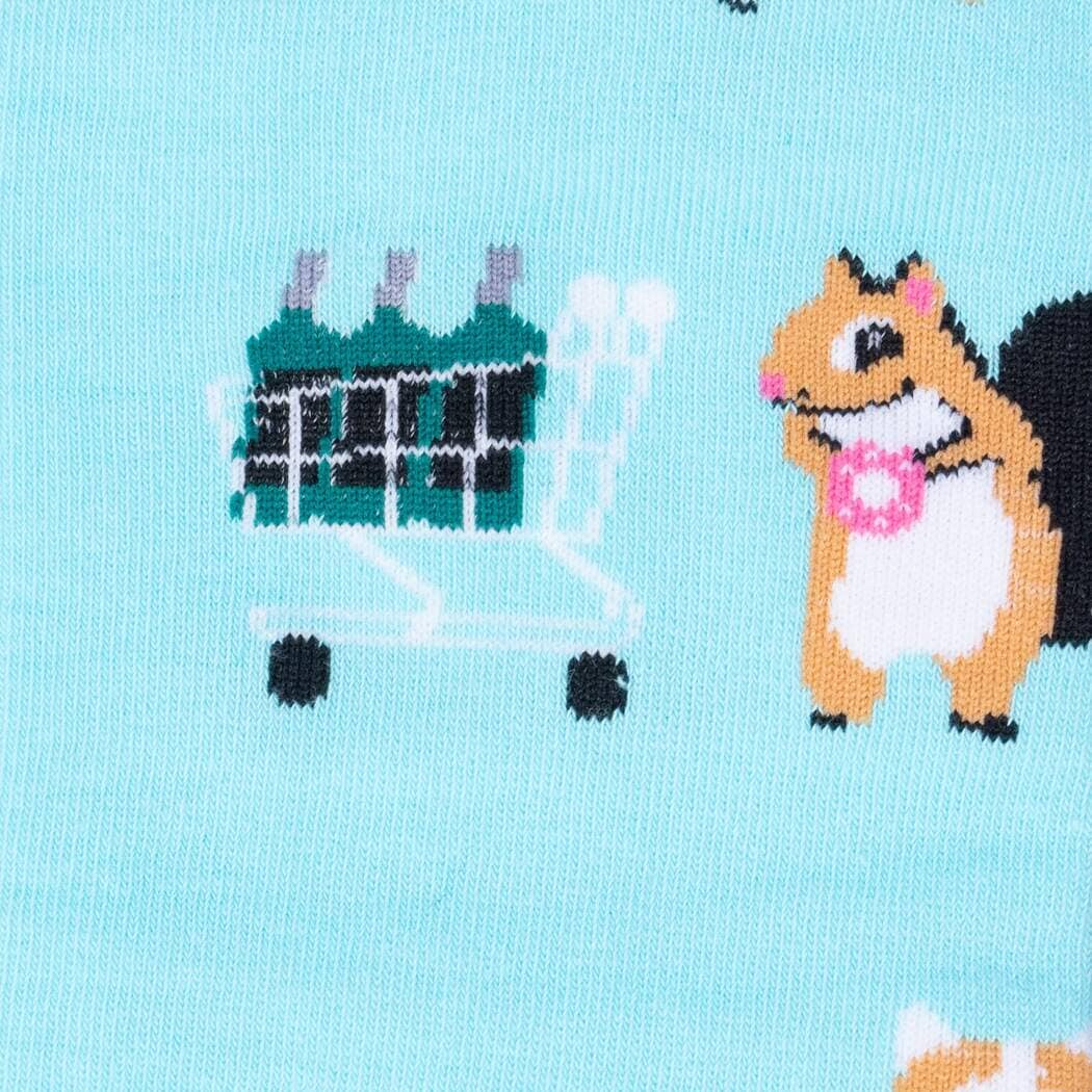 Close-up of a squirrel beside a green shopping cart full of bottles on the aqua sock