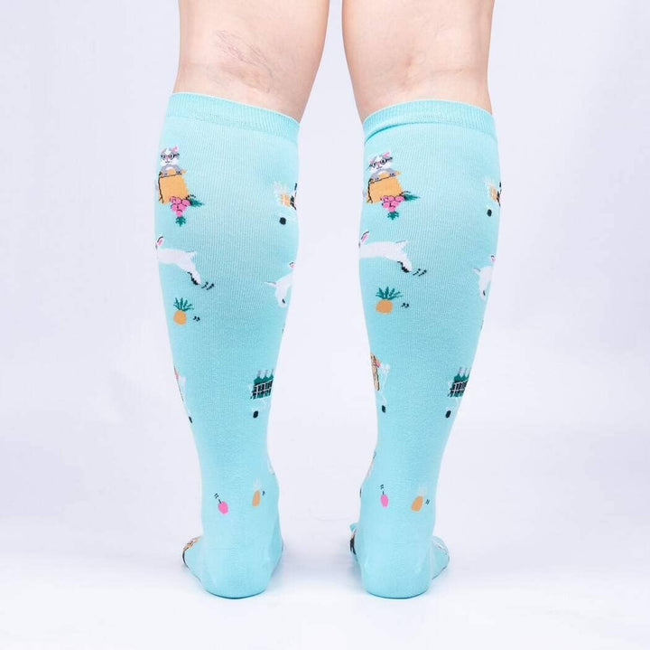 Back view of the aqua knee highs worn on legs, showing the bunnies, carts and pineapples
