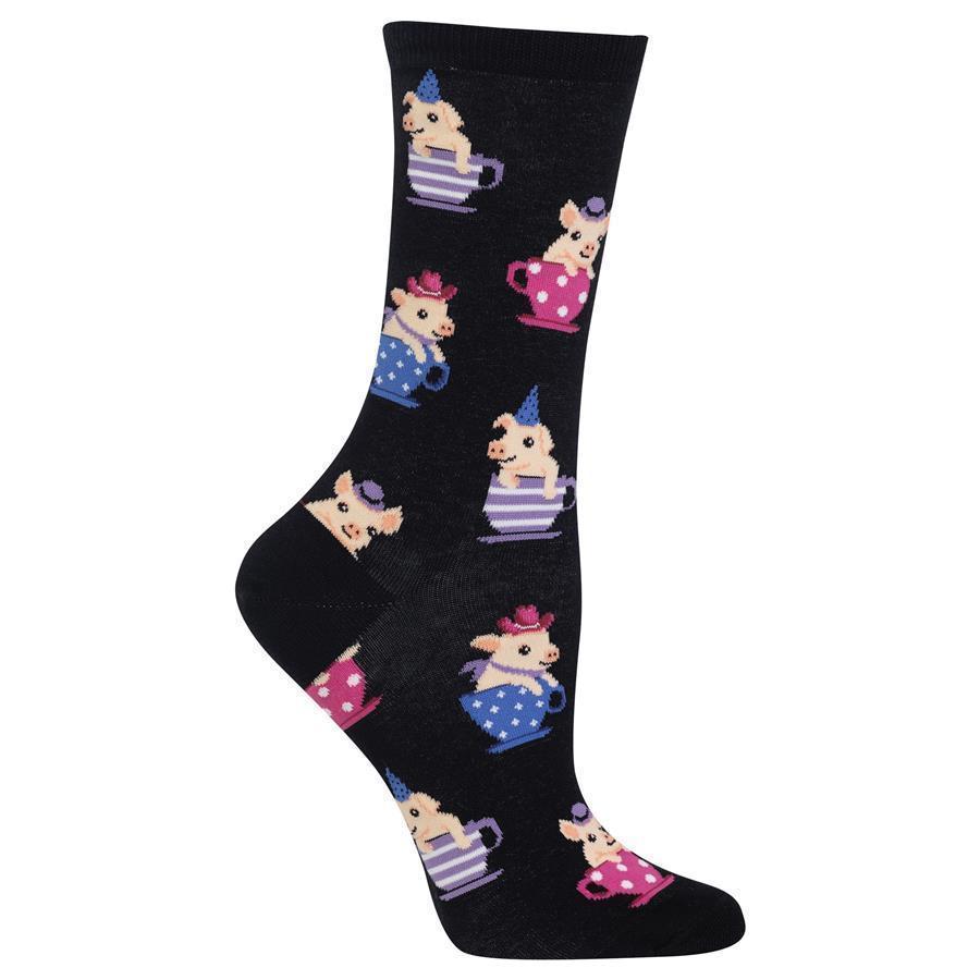 Women's black crew sock covered in pink piglets sitting in colorful polka-dot teacups with party hats