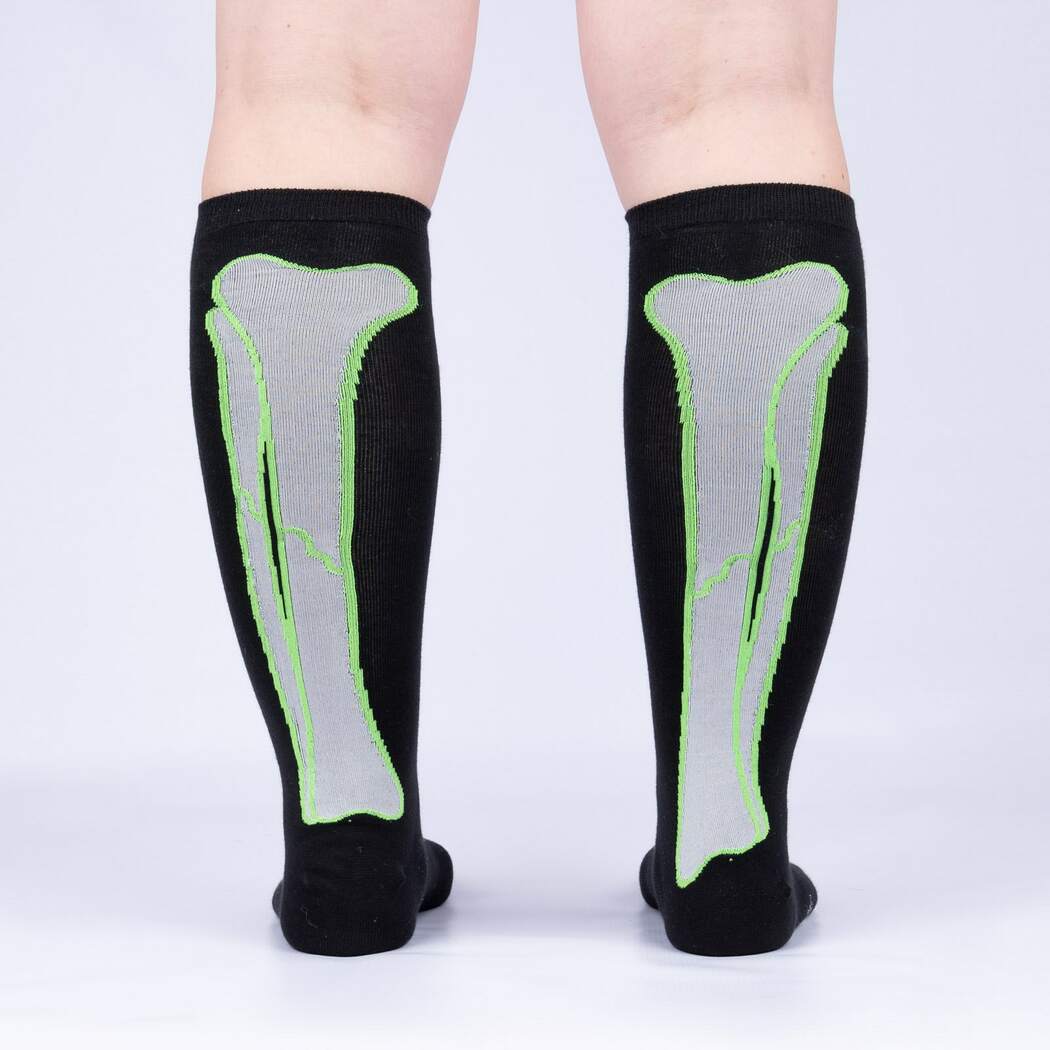 Back view of model wearing the skeleton-bone knee high socks showing the bones running up the calves