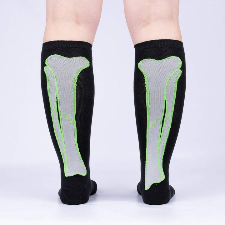 Back view of model wearing the skeleton-bone knee high socks showing the bones running up the calves
