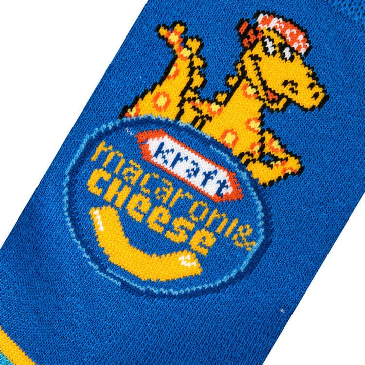 Close-up knit detail of the noodle dinosaur mascot above the Kraft Macaroni &amp; Cheese logo