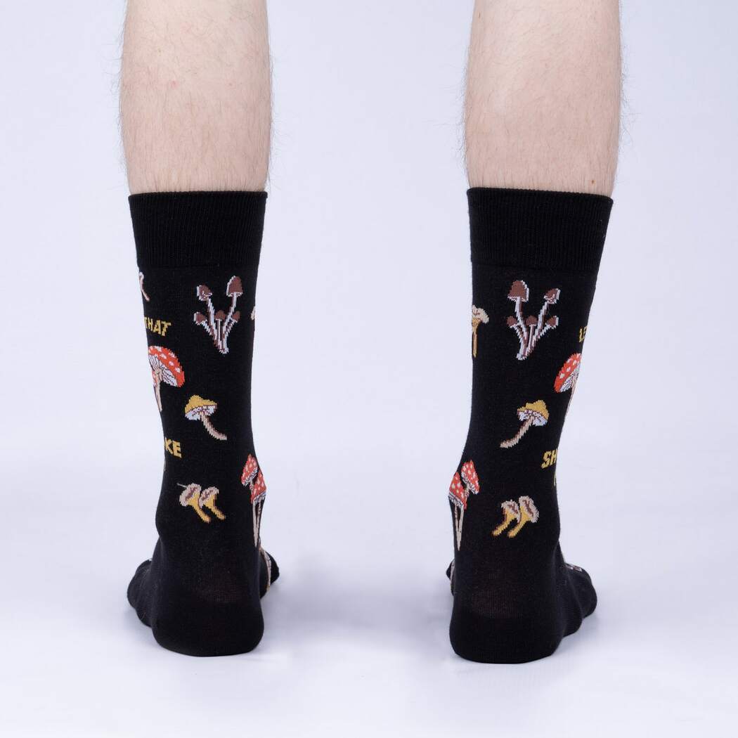Back view of model wearing the Let That Shiitake Go crew socks showing the mushroom pattern around the heel