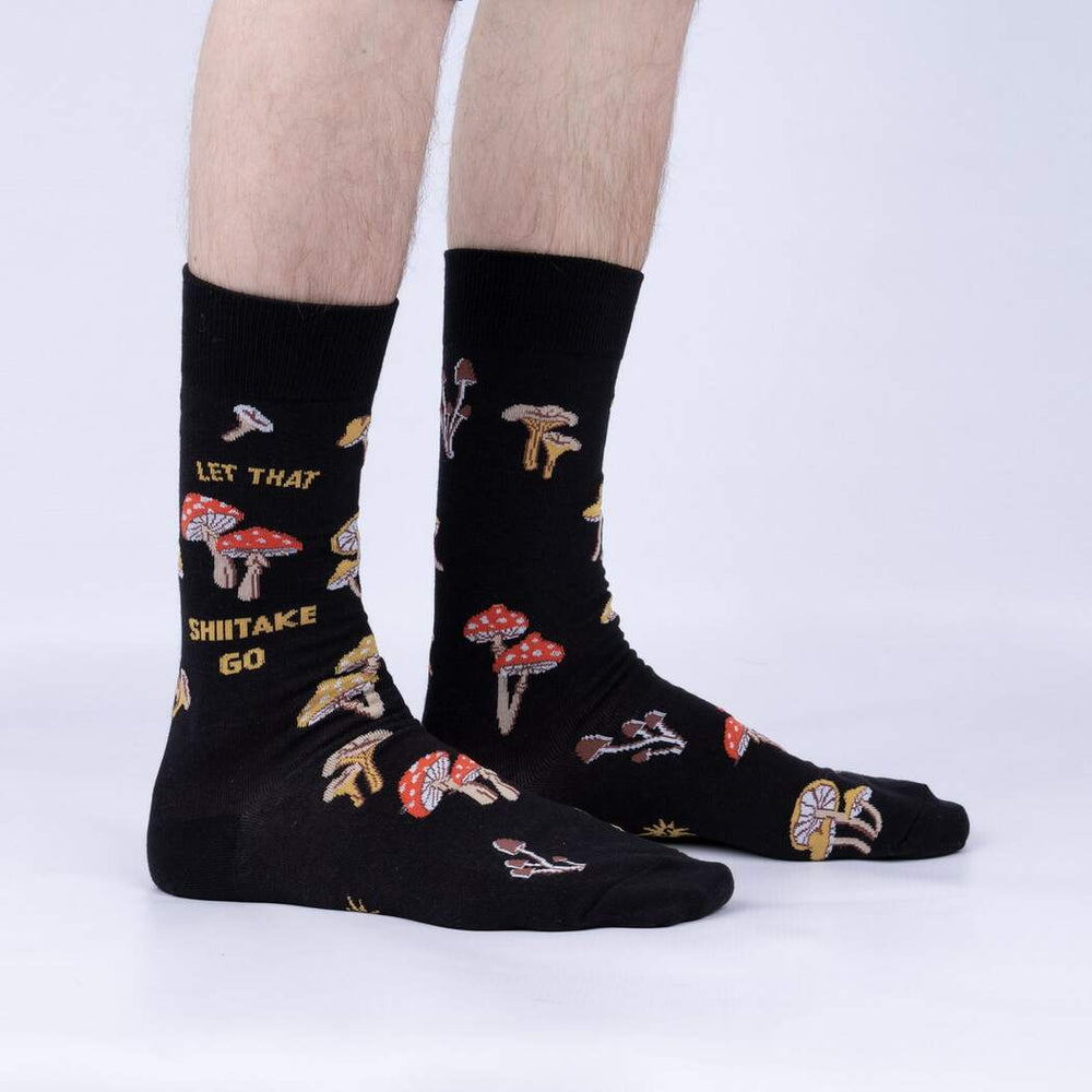 Side view of model wearing the black Let That Shiitake Go mushroom crew socks