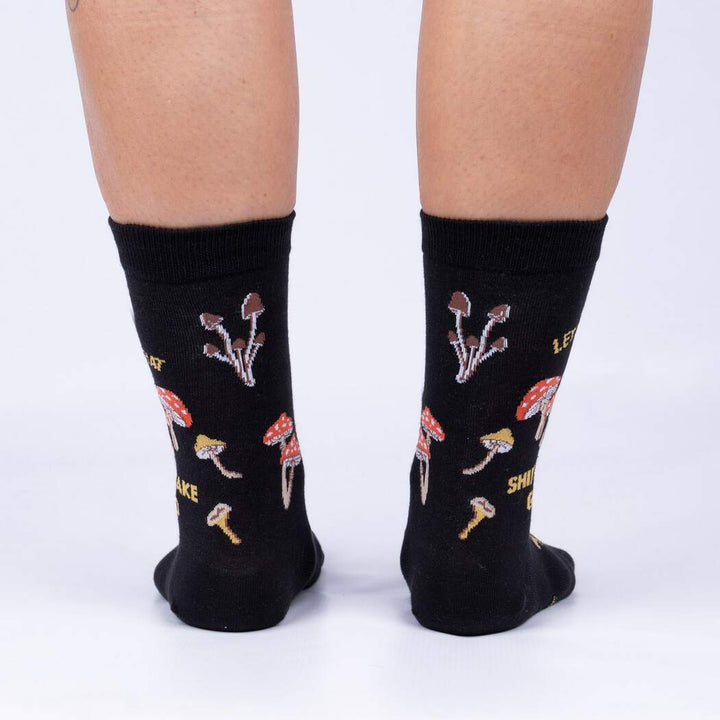 Back view of model wearing the Let That Shiitake Go crew socks showing the mushroom pattern around the heel