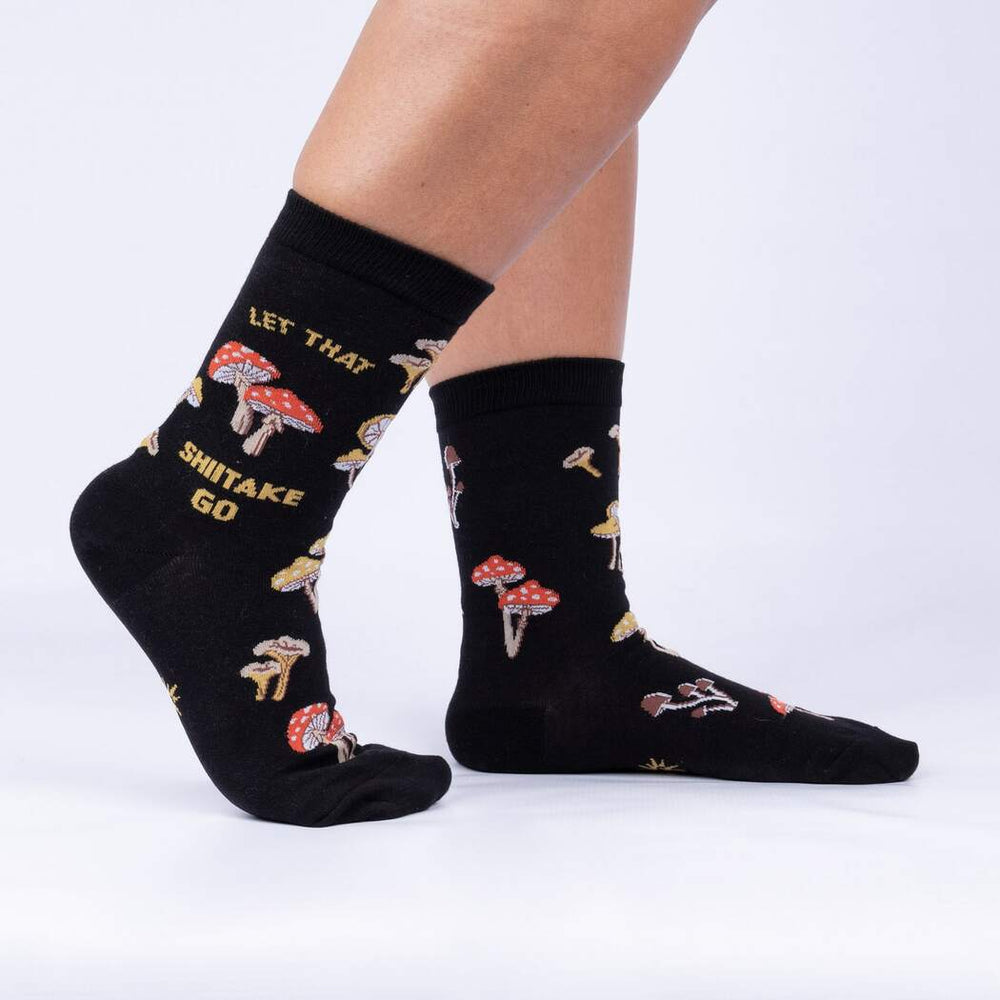 Side view of model wearing the black Let That Shiitake Go mushroom crew socks