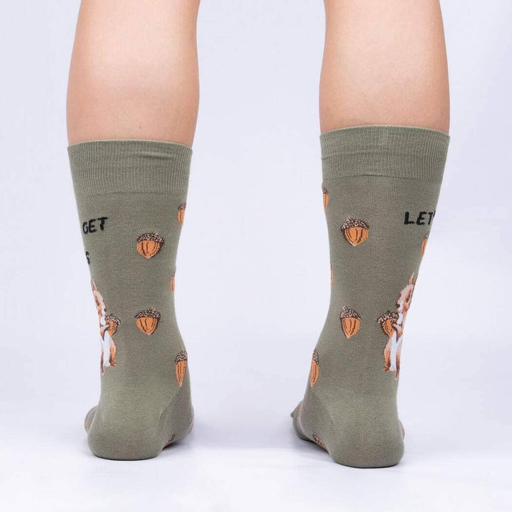 Back view of the olive socks worn on legs, showing acorns and squirrels wrapping around