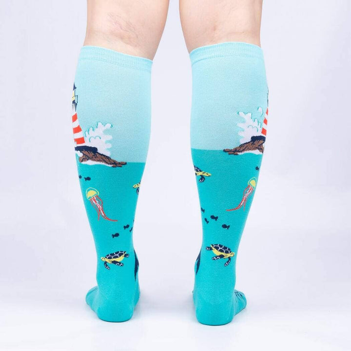 Back view of the lighthouse knee highs worn on legs, showing the lighthouse, turtles and jellyfish