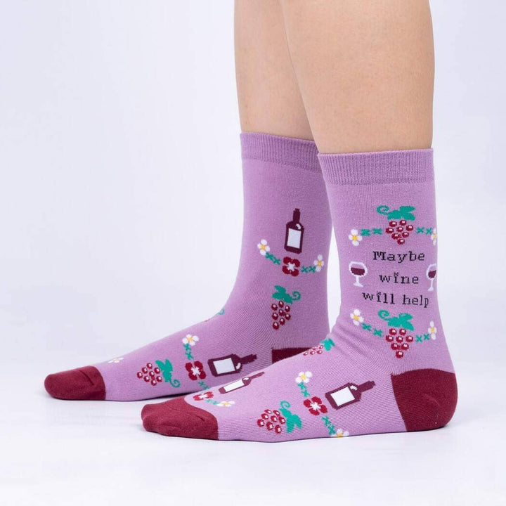 Side view of the mauve wine socks worn on legs, showing the bottles, grapes and floral motifs
