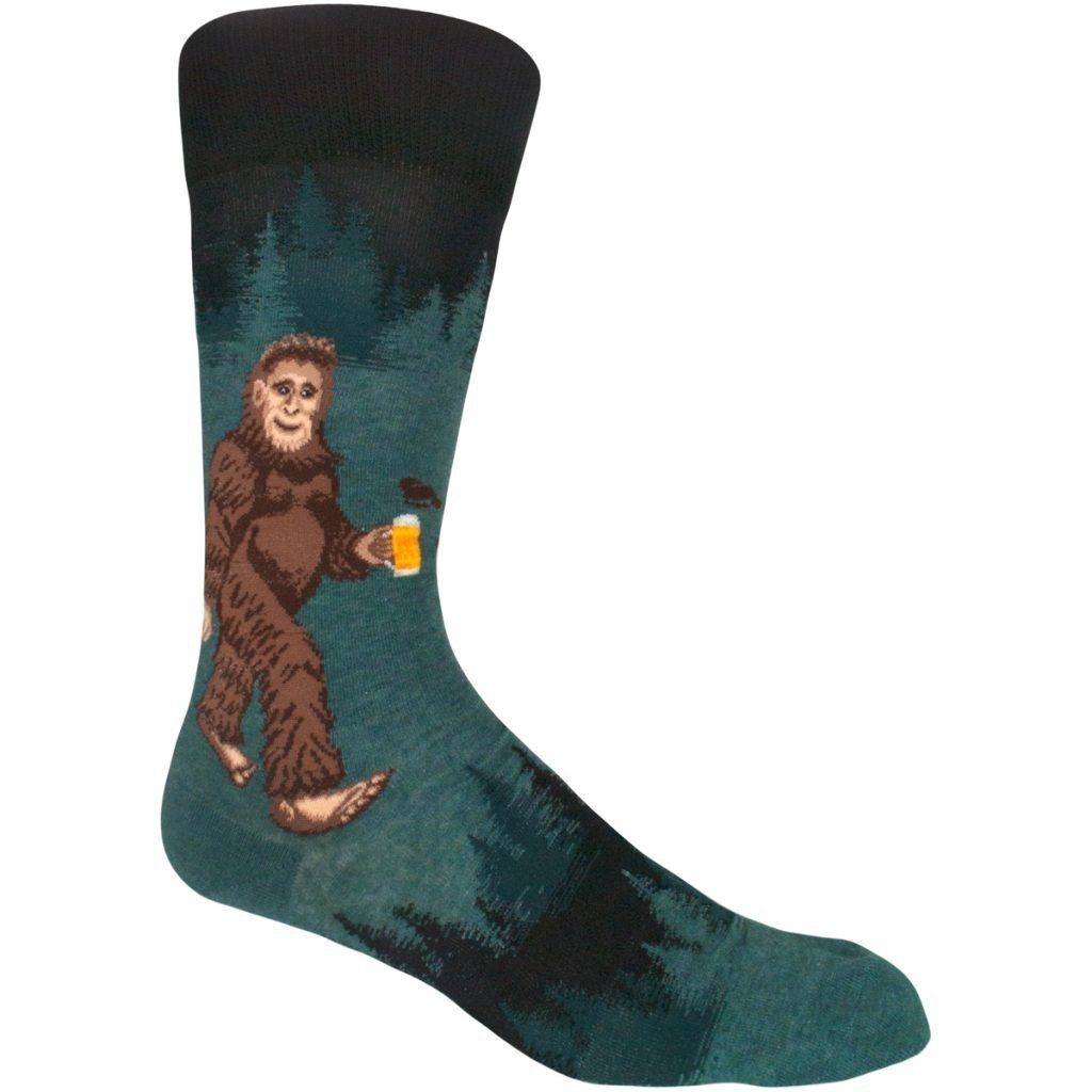 Teal and black crew sock with Bigfoot walking through pine trees holding a glass of beer