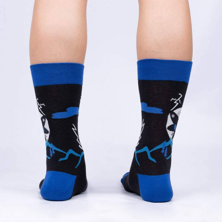 Back view of the Mothman crew socks on legs, showing lightning bolts and the mountain silhouette