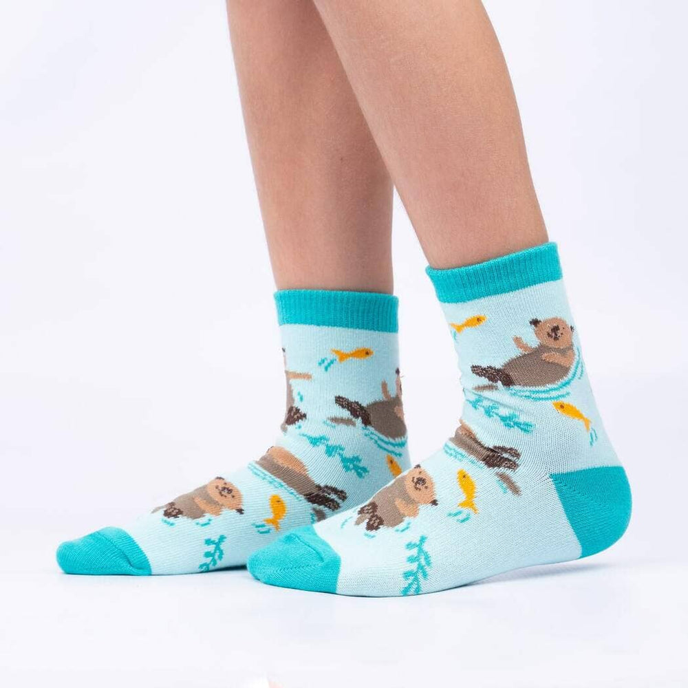 Child wearing the aqua otter socks showing otters holding hands among kelp
