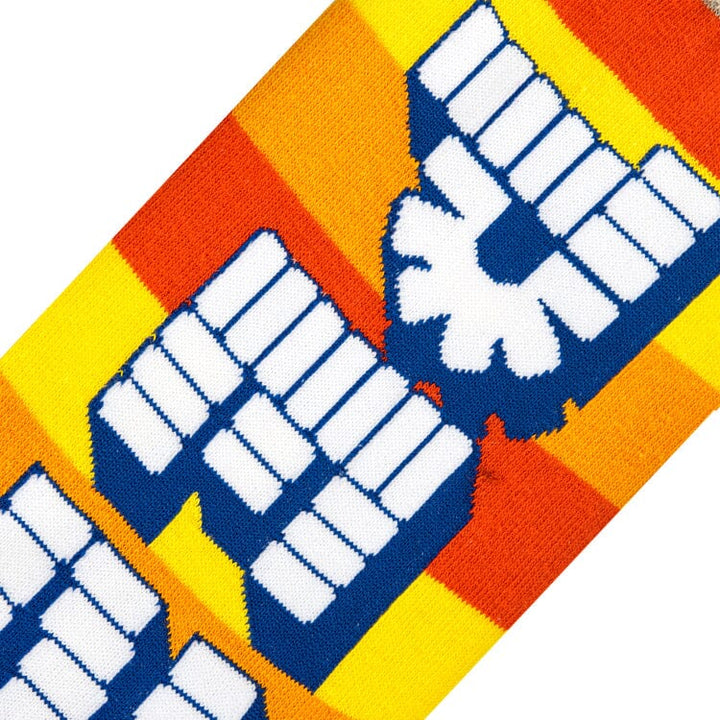 Close-up knit detail of the blue and white Pez logo against orange and yellow stripes