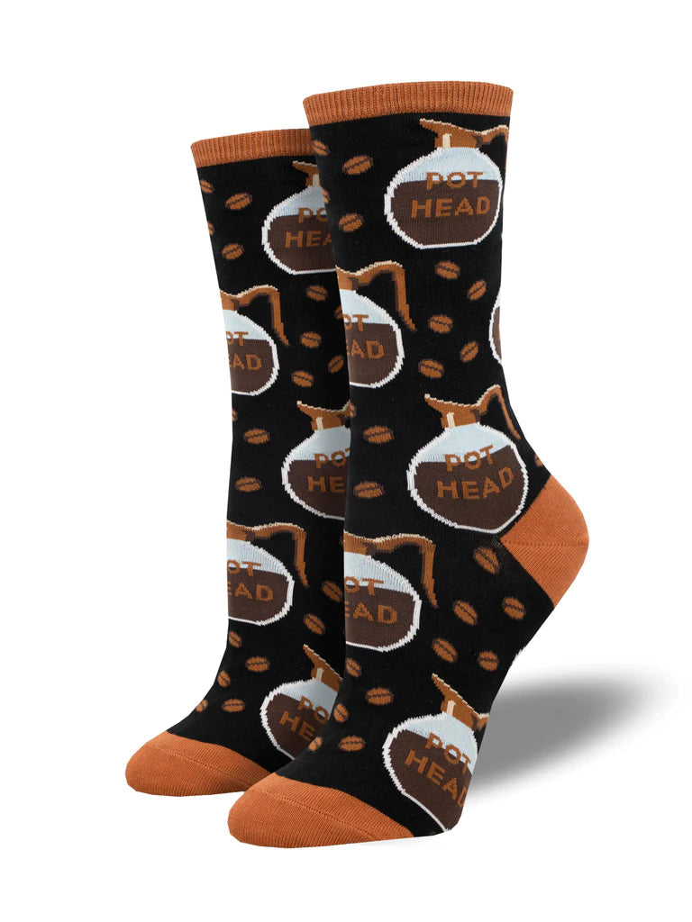 Women's black crew socks patterned with foamy POT HEAD coffee pots and scattered beans, with rust heel and toe