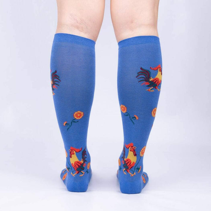 Back view of the rooster knee high socks on legs, showing roosters and marigolds on blue
