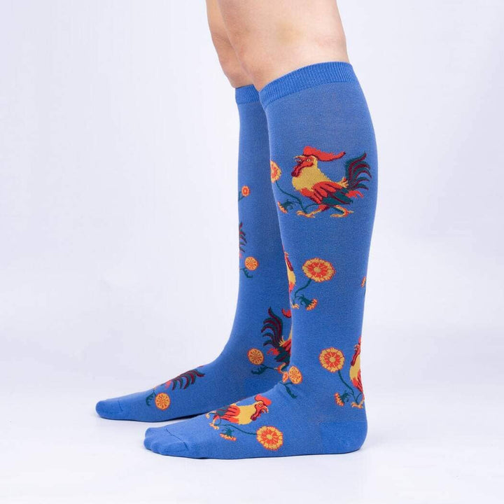 Side view of the rooster knee high socks worn on legs, showing the bird and flower pattern up the calf