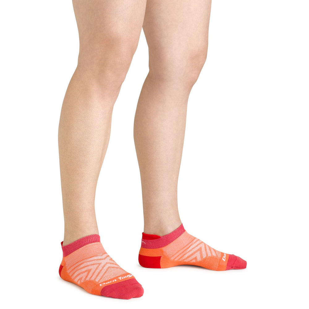 Women's coral no-show running socks worn on a model, back view showing the heel tab