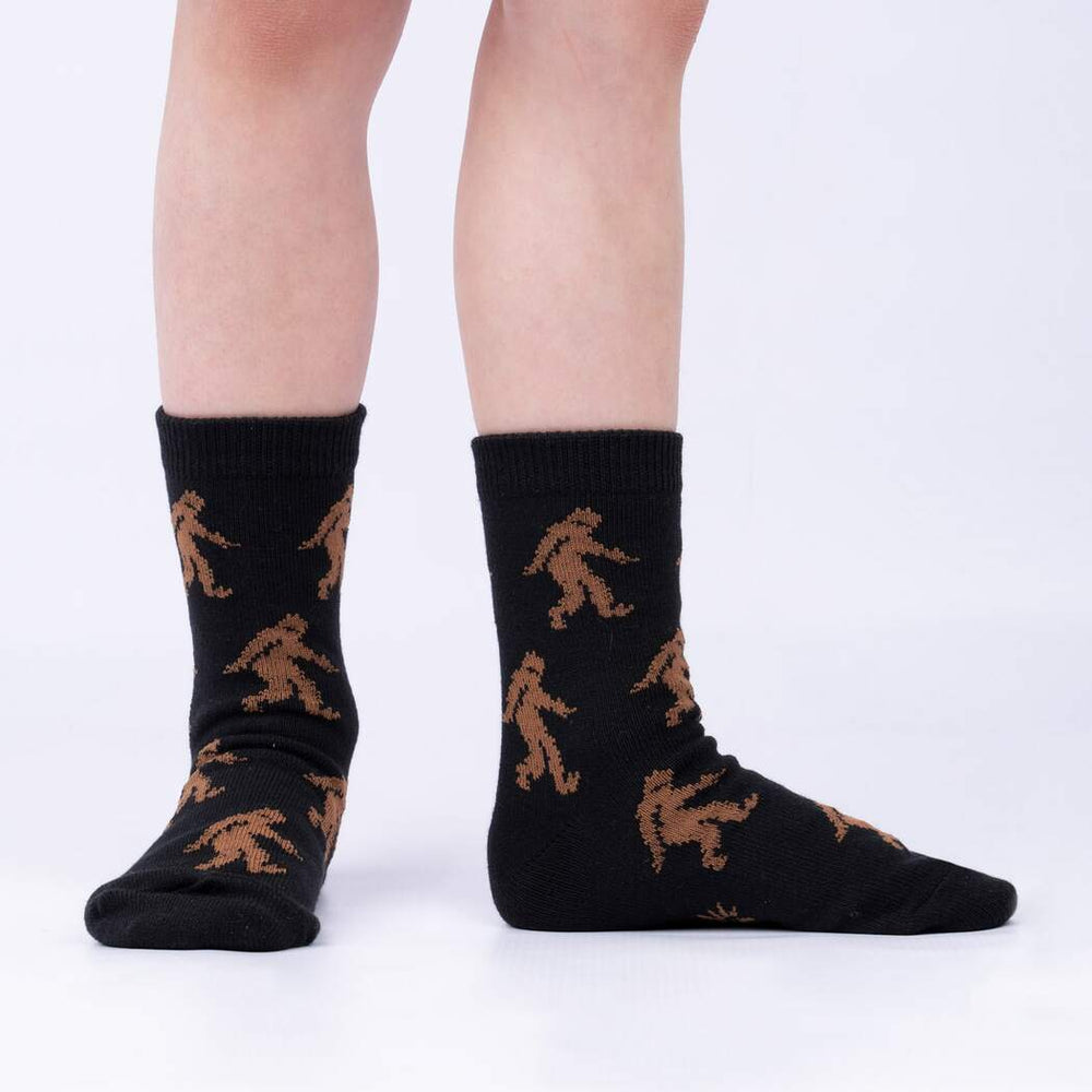 Child wearing the black Sasquatch silhouette print junior crew socks, side view