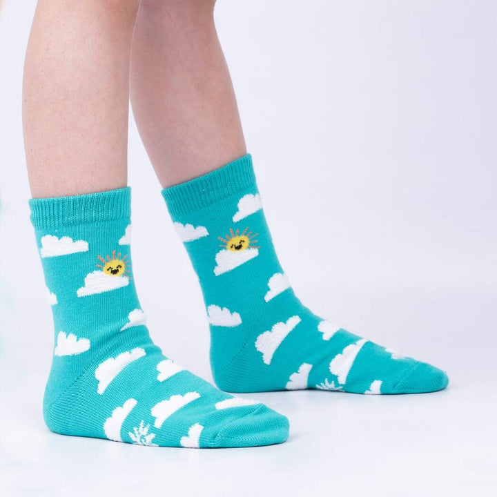 Side view of child wearing the teal cloud-and-sun crew socks with a smiling sun