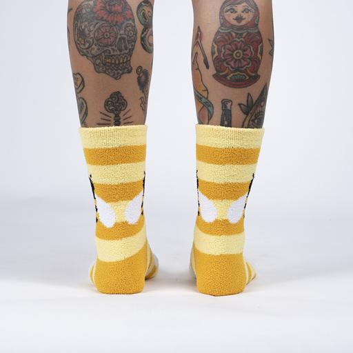 Back view of the fuzzy bumblebee slipper socks worn, showing the yellow and gold stripes