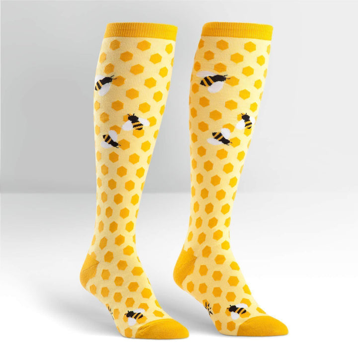 Pair of yellow knee high socks with honeycomb hexagons and black-and-yellow bumblebees
