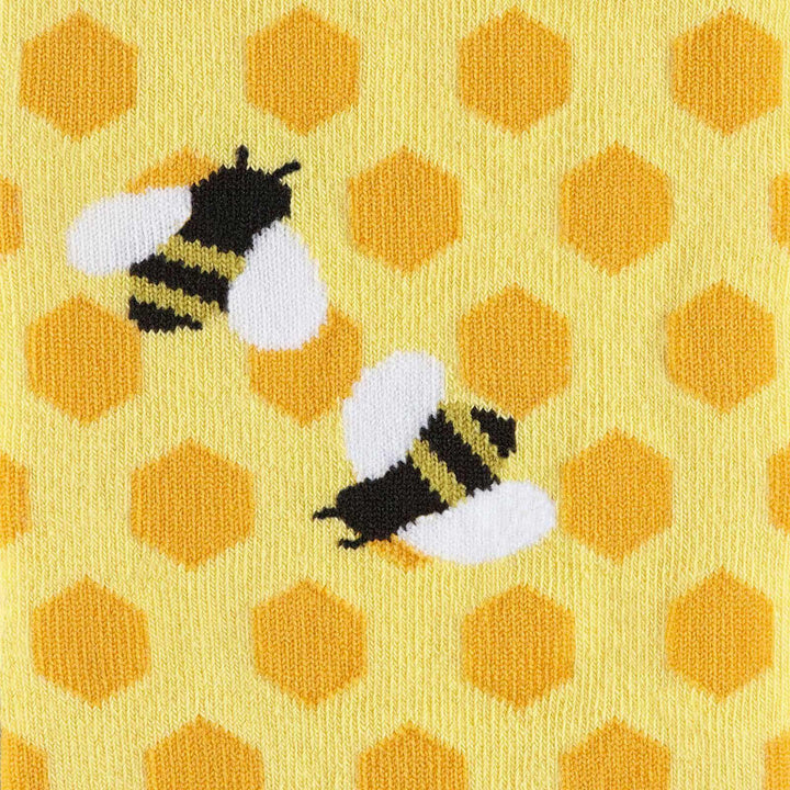 Close-up of two bumblebees with white wings on a yellow honeycomb sock