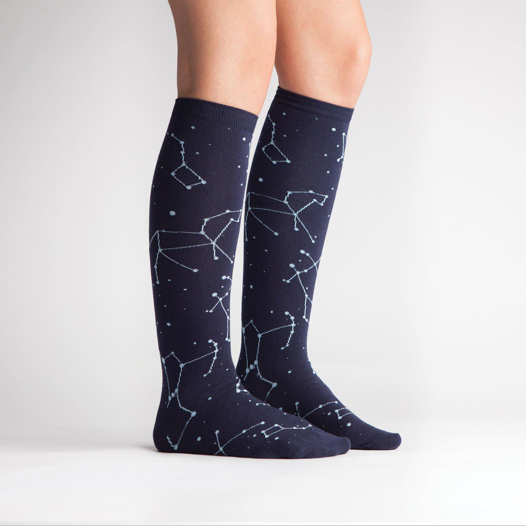 Side view of navy constellation knee high socks on a model