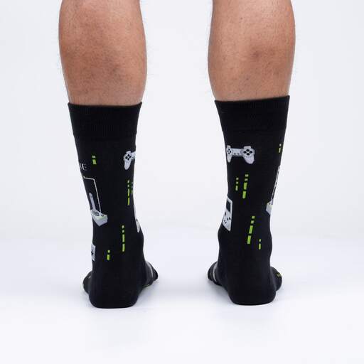 Back view of the black gaming crew socks on legs showing gamepads and neon green accents