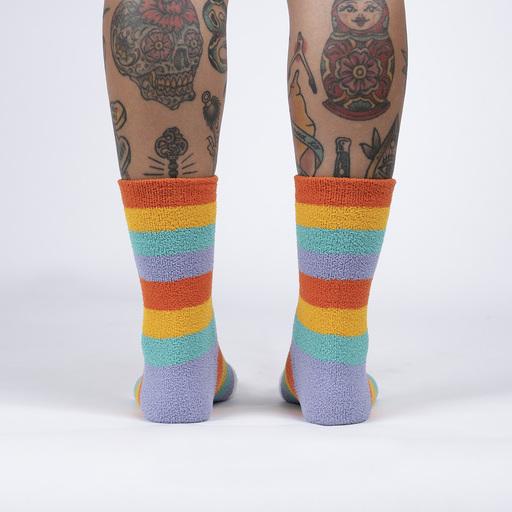 Back view of the fuzzy rainbow striped slipper socks worn, showing the stacked colorful stripes