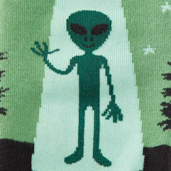 Close-up of a green alien waving inside a UFO tractor beam