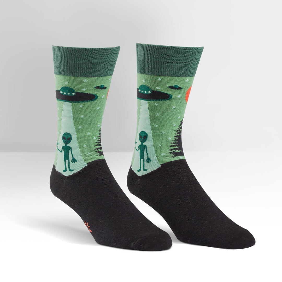 Men's green crew socks with UFOs beaming down a waving alien