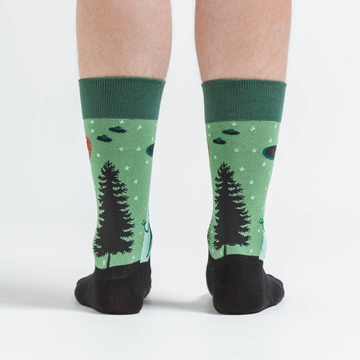 Back view of green alien abduction crew socks on a model
