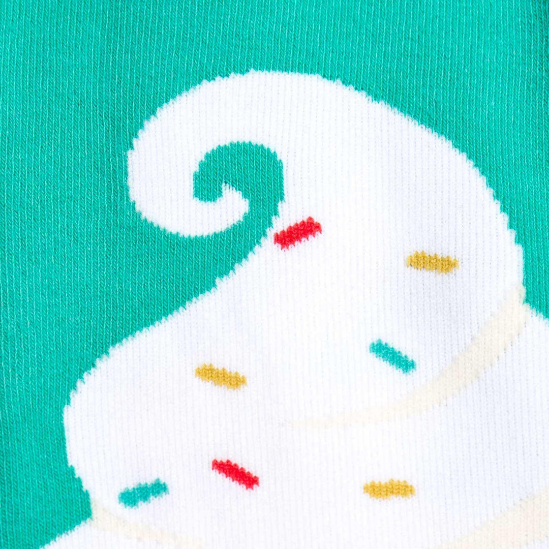 Close-up detail of the ice cream knee-high sock showing the swirled vanilla top and colorful sprinkles on a teal background.